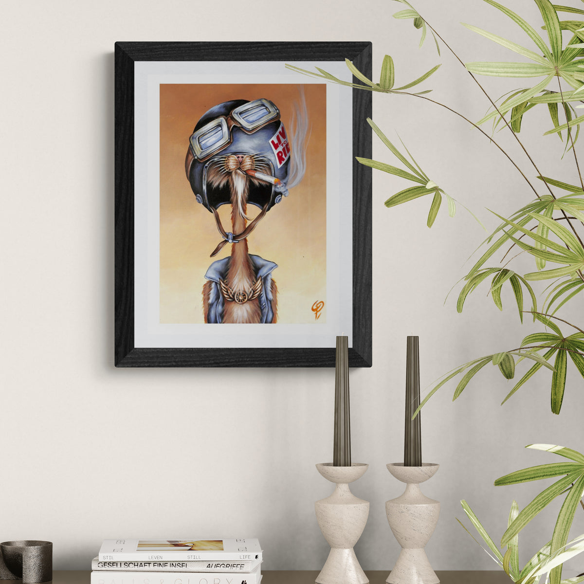 Framed artwork of a cat  wearing a helmet on a wall with decorative elements.