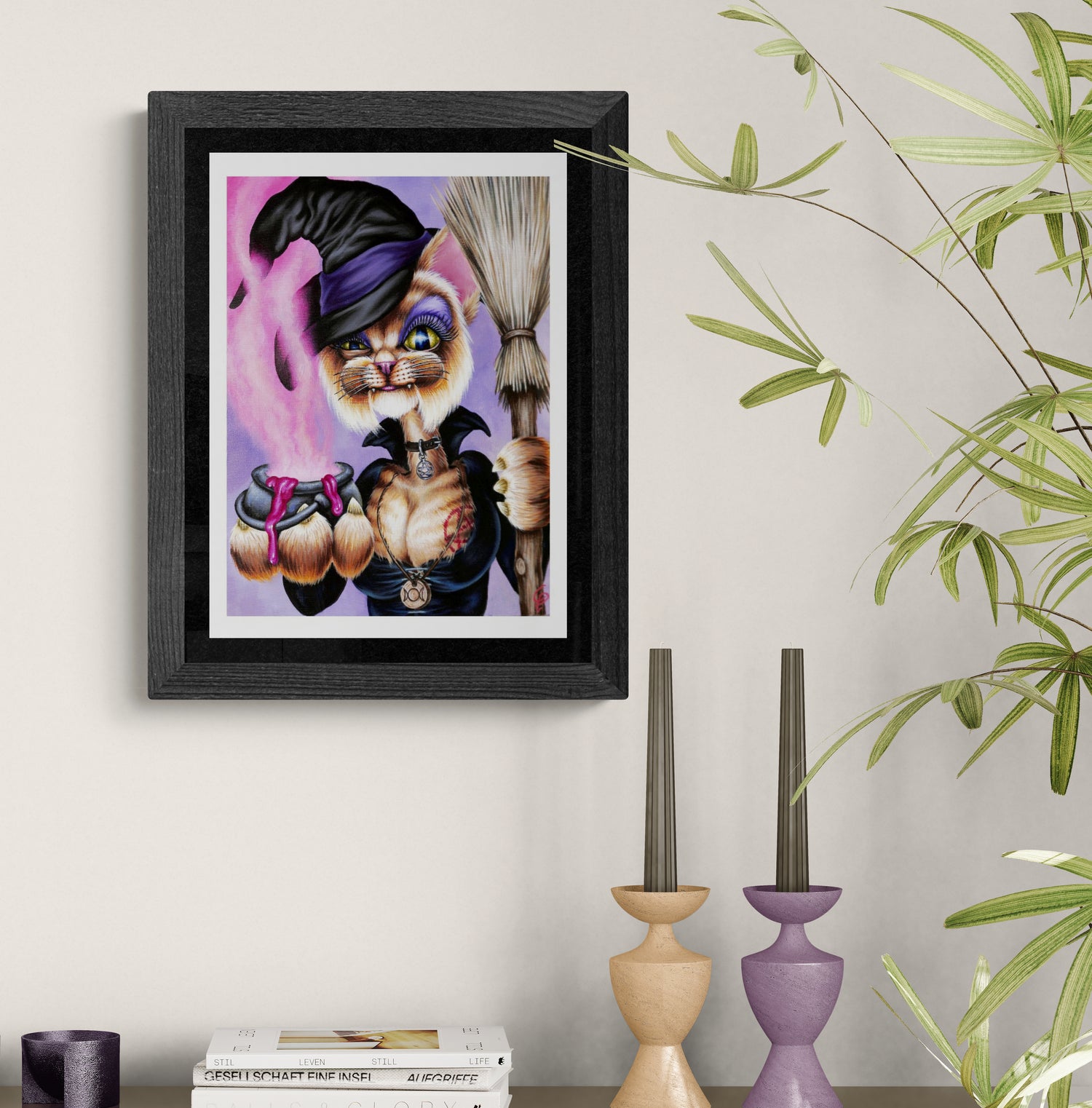 Framed artwork of a cat with a hat and broom on a wall with decorative candles and books.
