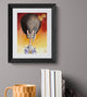 Framed artwork of a cat with a sword on a gray wall above books and a mug.
